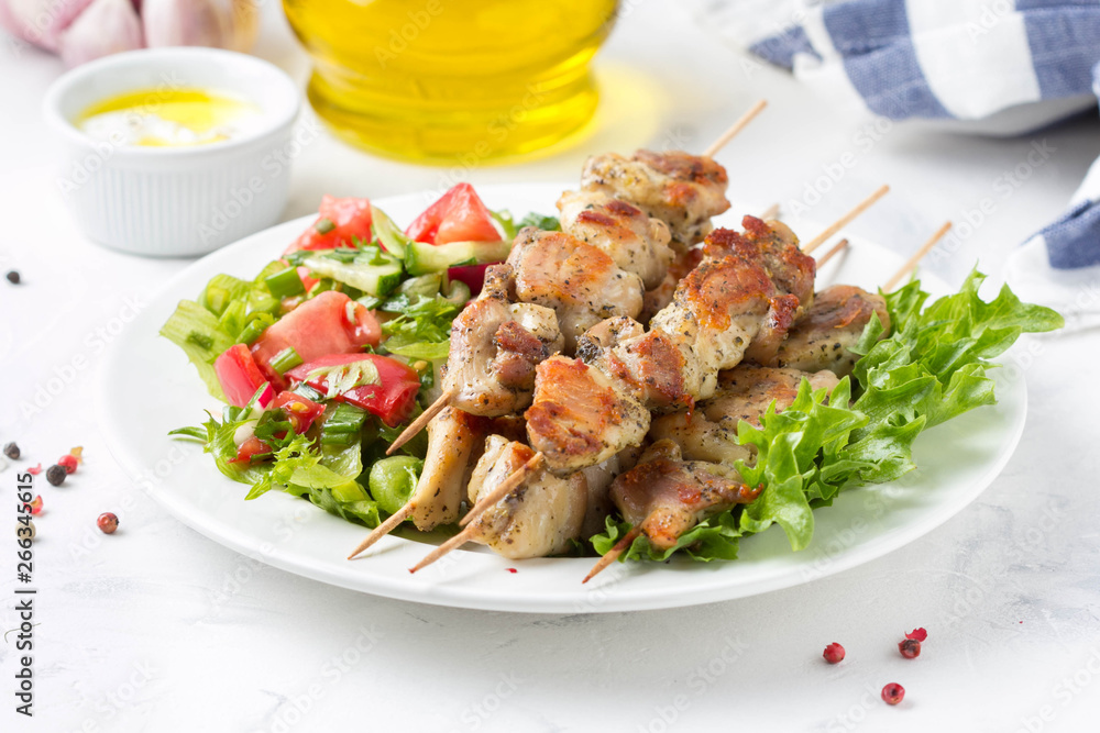 Meat kebabs (chicken, Turkey, pork) on wooden skewers with vegetable salad and yogurt sauce. Spring picnic, grilled food, delicious lunch Meat kebabs (chicken, Turkey, pork) on wooden skewers with vegetable salad and yogurt sauce. Spring picnic, grilled food, delicious lunch