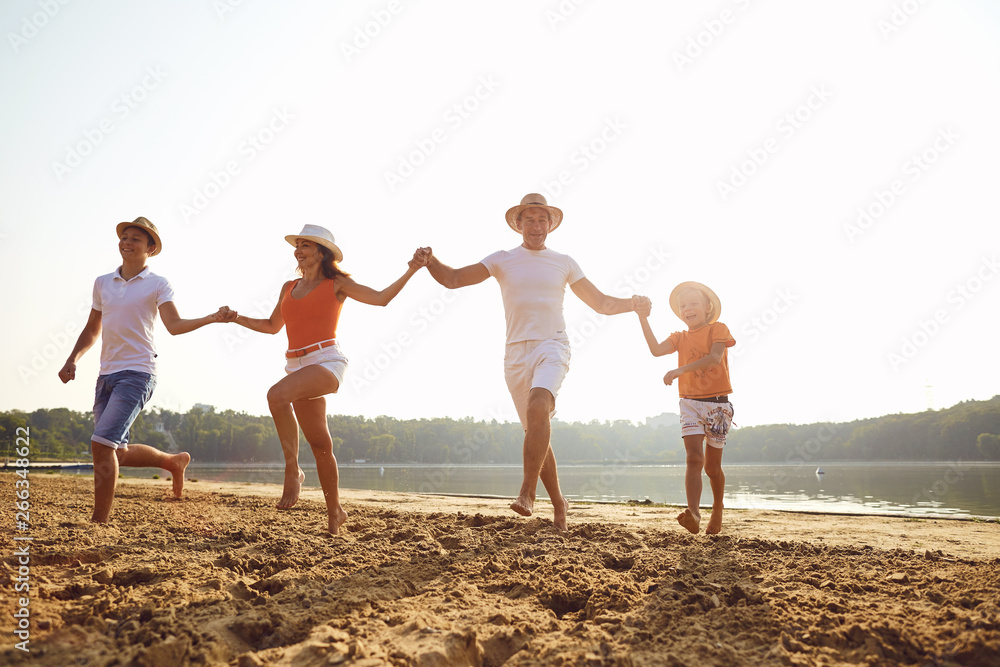 Happy family playing on the beach at sunset Happy family playing on the beach at sunset
