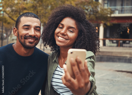 Smiling young couple taking selfie on smart phone