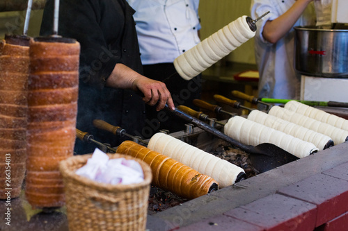 Trdelnik or Trdlo or Kurtosh Kalach being baked in a street bakery in Budapest