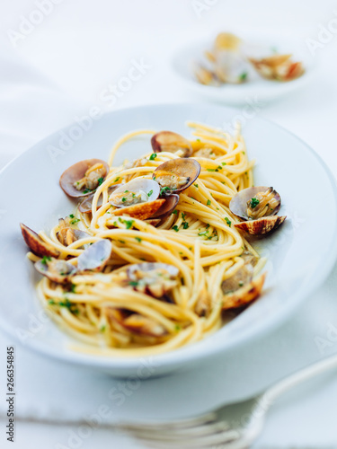 Spaghetti vongole. Spaghetti with venus clams on white plate