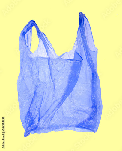 Blue plastic shopping bag on yellow background.