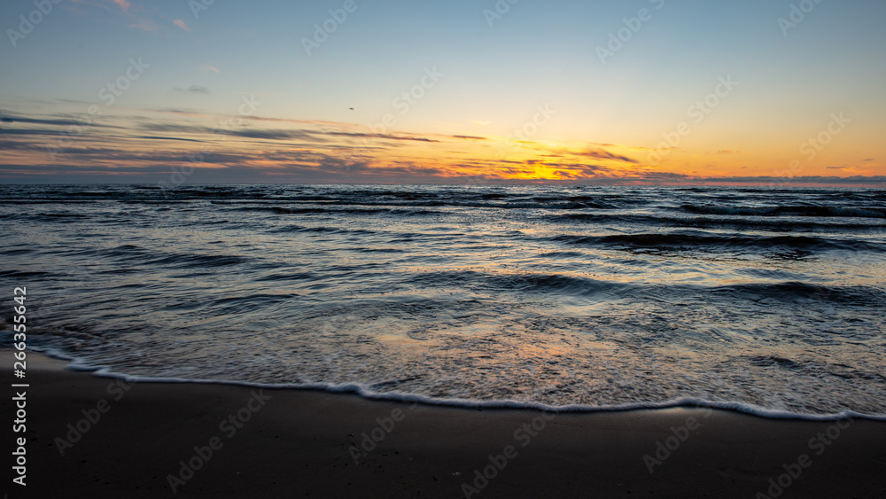 colorful sunset over the sea lake with dark red clouds colorful sunset over the sea lake with dark red clouds