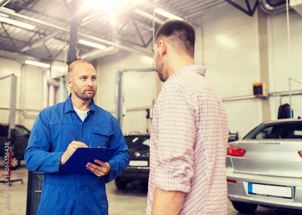 Fototapeta premium auto service, repair, maintenance and people concept - mechanic with clipboard talking to man or owner at car shop