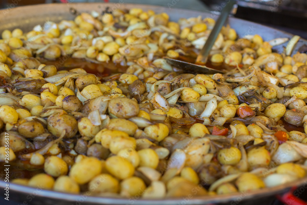 Young fried, whole village potatoes with onions in a large pan. Vending. Food Festival in Hungary Young fried, whole village potatoes with onions in a large pan. Vending. Food Festival in Hungary