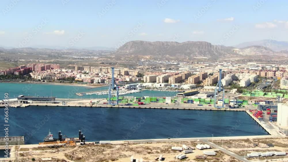 A beautiful wide slow-moving aerial shot of the Alicante harbor in Spain surrounded by the magnificent landscape and mountains on a beautiful summer day. Film LUT and grade added. A beautiful wide slow-moving aerial shot of the Alicante harbor in Spain surrounded by the magnificent landscape and mountains on a beautiful summer day. Film LUT and grade added.