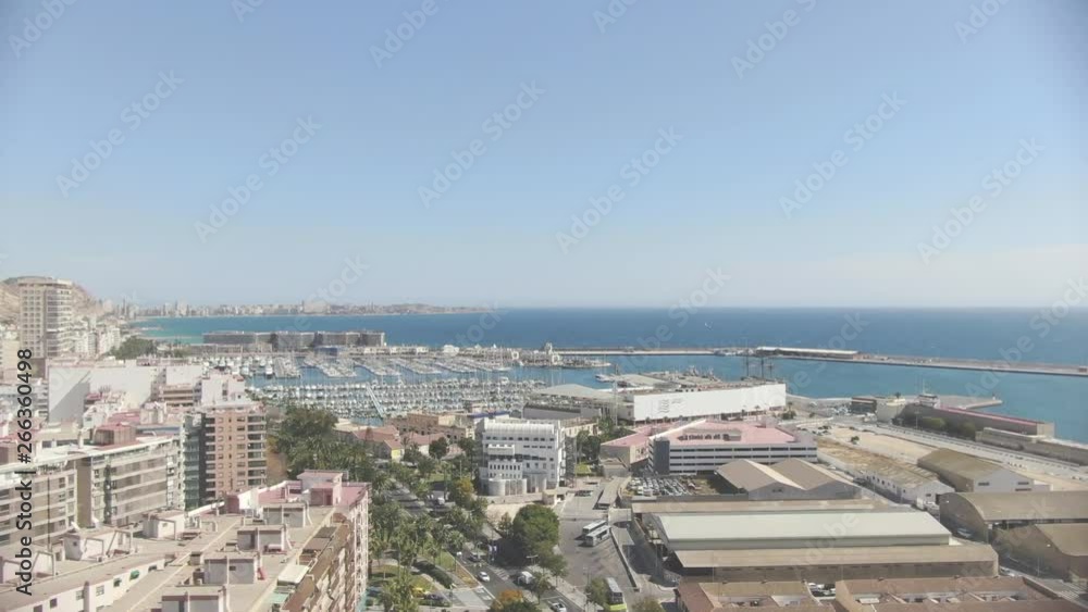 A beautiful wide slow-moving aerial shot of the Alicante harbor in Spain surrounded by the magnificent landscape and mountains on a beautiful summer day. Film LUT and grade added. A beautiful wide slow-moving aerial shot of the Alicante harbor in Spain surrounded by the magnificent landscape and mountains on a beautiful summer day. Film LUT and grade added.