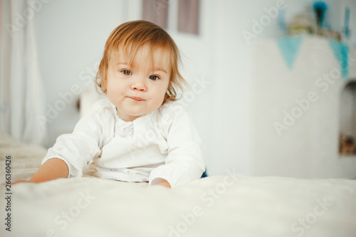 Cute little girl sitting in a room. Child have fun at home