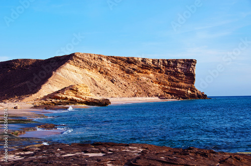 A cliff on a coastline in Oman with deep blue water