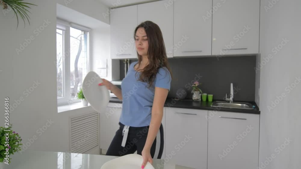 enjoying loneliness, merry female having fun and sings with dishes in hands at cuisine at home in weekend, slow motion enjoying loneliness, merry female having fun and sings with dishes in hands at cuisine at home in weekend, slow motion