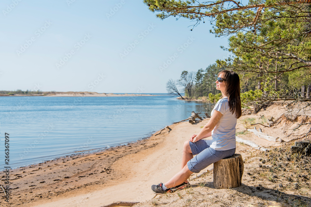 Portrait of smiling young woman laying on sea coast