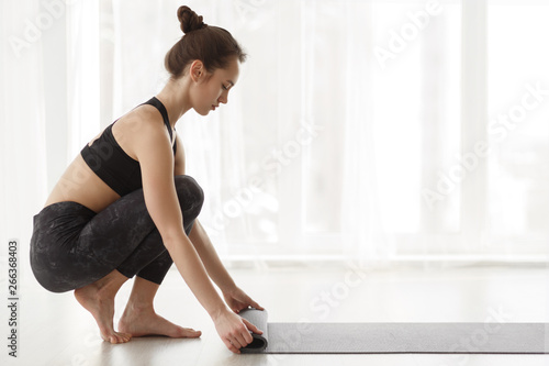 Girl Rolling Mat After Yoga Class, Side View