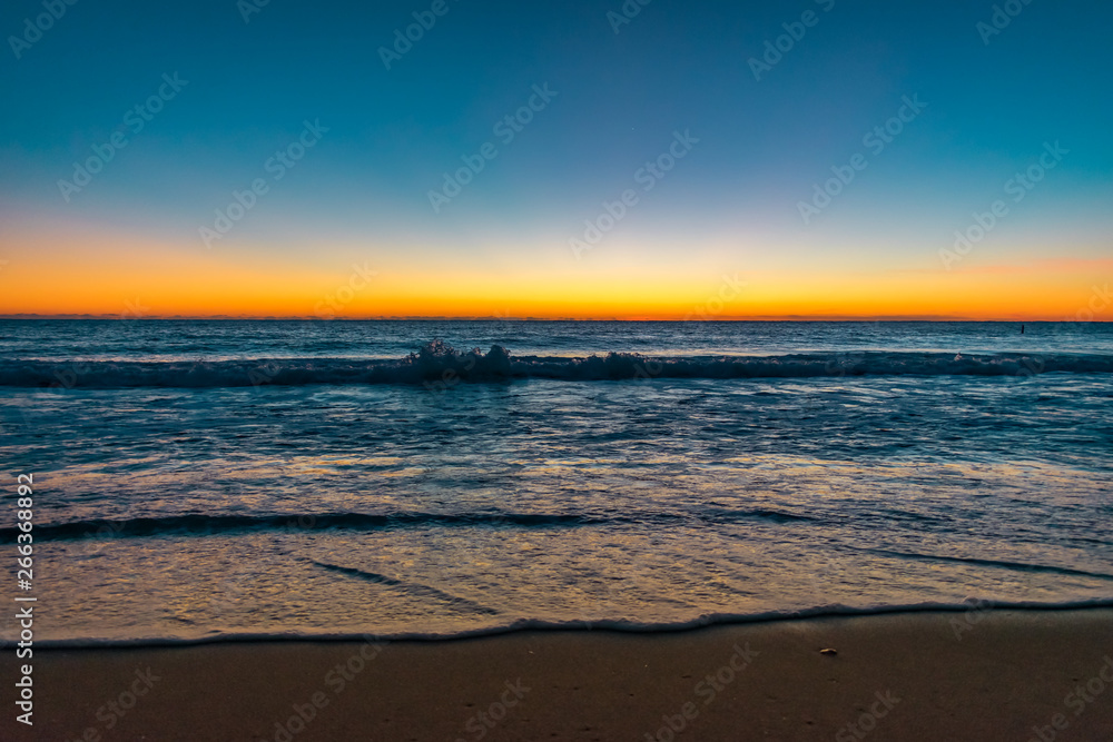 clear blue and orange sky over the ocean at dawn