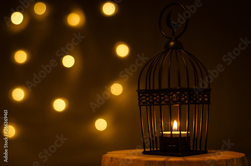 Beautiful Lantern that have moon symbol on top with bokeh light on dark background for the Muslim feast of the holy month of Ramadan Kareem. © baramyou0708