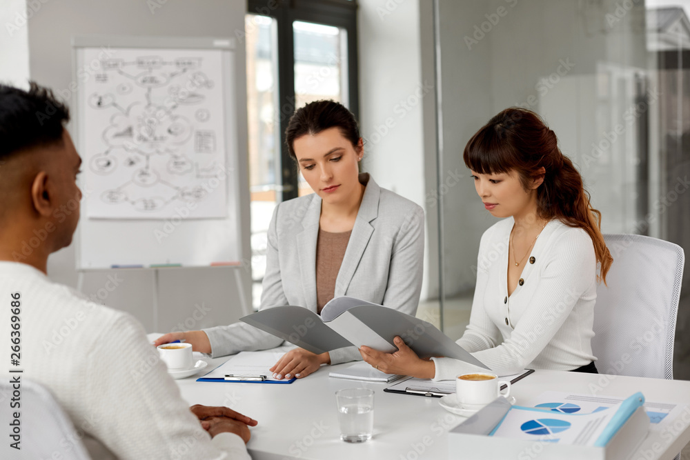 new job, hiring and employment concept - international team of recruiters having interview with indian male employee at office new job, hiring and employment concept - international team of recruiters having interview with indian male employee at office