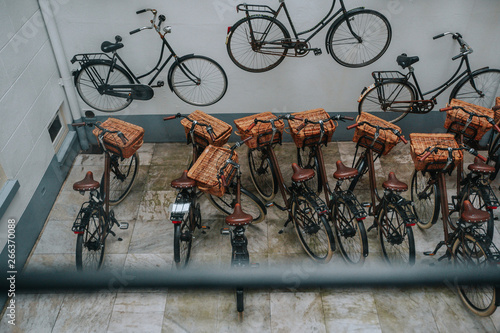 View from the window of a parked group of bicycles at the house with a white facade decorated with real bikes