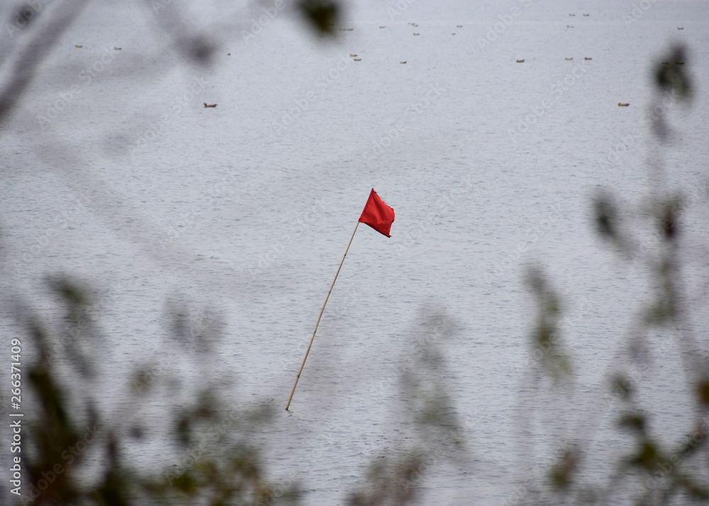 Warning Red Flag in the waters - Natural calamity conceptual image Warning Red Flag in the waters - Natural calamity conceptual image