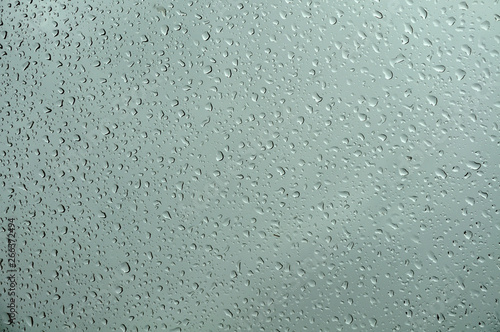 water drops on a glass sheet on gray rainy day