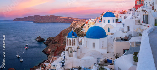 The famous three blue domes in Santorini at sunset