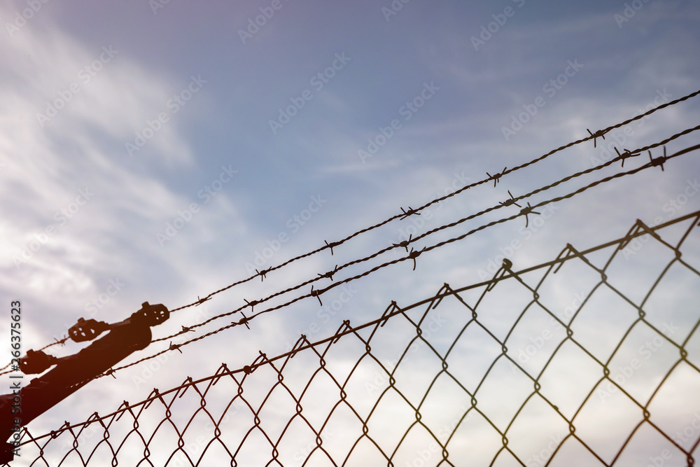 Wire fence with a blue sky with clouds Wire fence with a blue sky with clouds