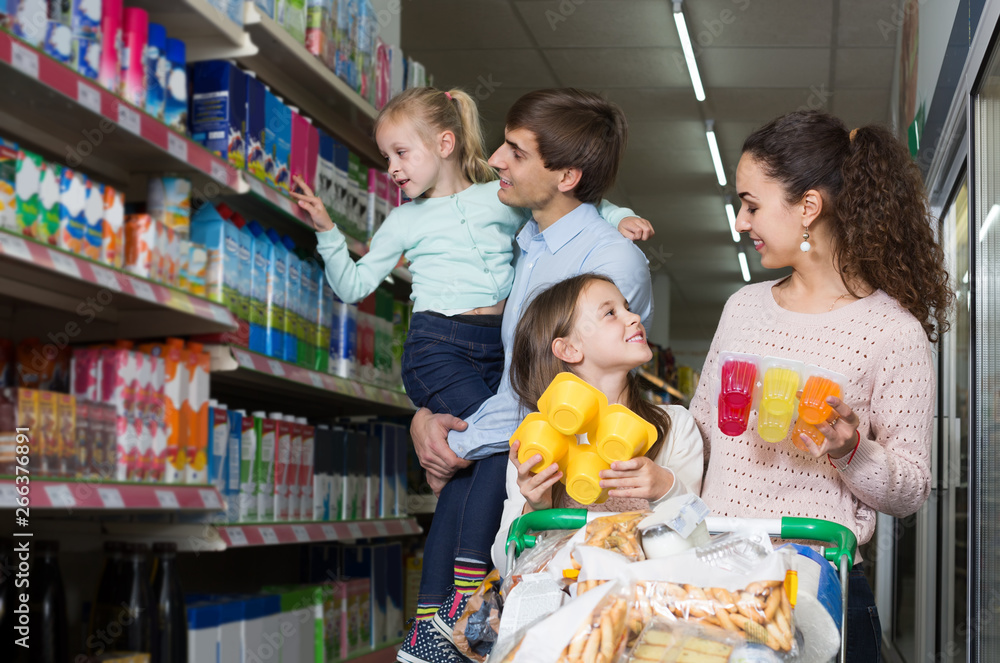  customers with children selecting sweet dairy products in hypermarket