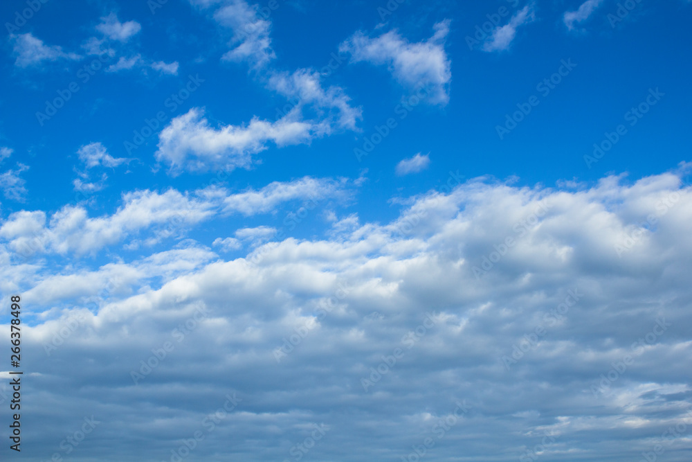 Cloudscape image with blue sky and white fluffy clouds