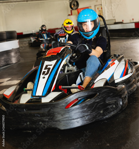 female in helmet driving car for karting