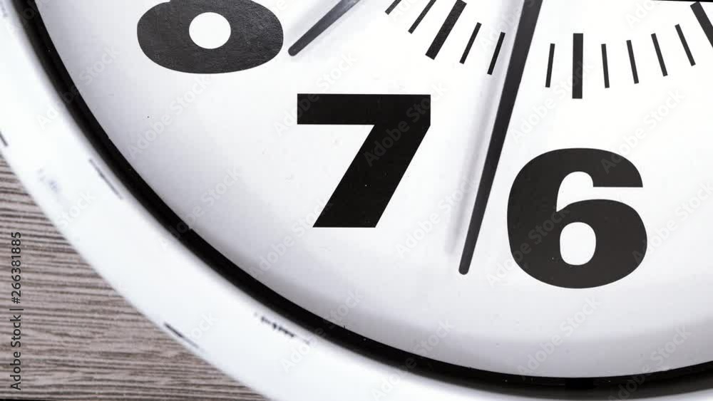 The Time On The Clock Seven. Clock With The Red Arrow Running In The Background Of The Arabic Numerals.