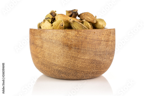 Lot of whole true cardamom pod in a wooden bowl isolated on white background