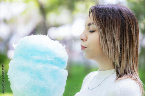 Close up portrait of a happy smiling excited girl holding cotton candy at amusement park.sad girl looking at cotton candy