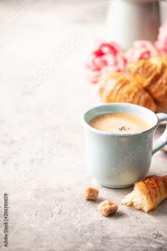 Morning coffee, croissants and spring tulips on light grey backg