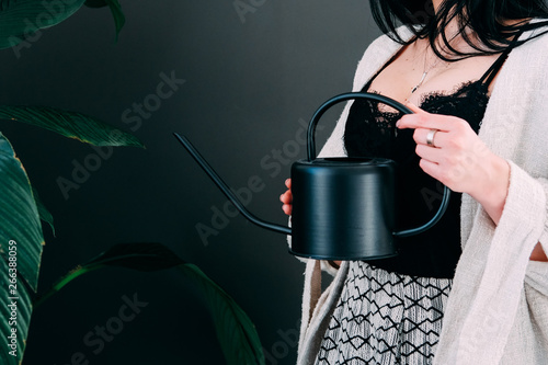 Woman watering pot flowers in the offiice photo