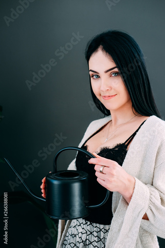 Woman watering pot flowers in the offiice photo