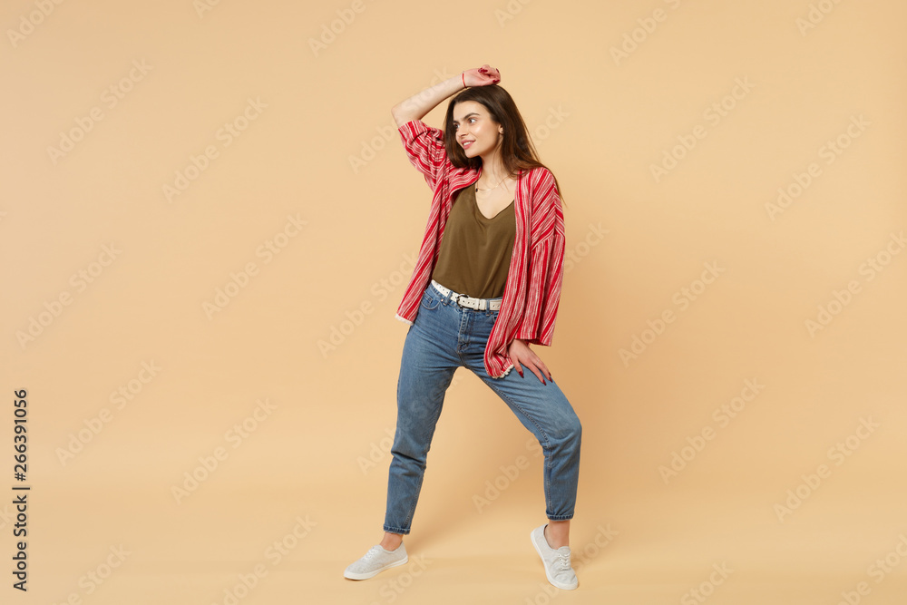 Portrait of charming young woman in casual clothes looking aside putting hand on head isolated on pastel beige wall background in studio. People sincere emotions lifestyle concept. Mock up copy space. Portrait of charming young woman in casual clothes looking aside putting hand on head isolated on pastel beige wall background in studio. People sincere emotions lifestyle concept. Mock up copy space.