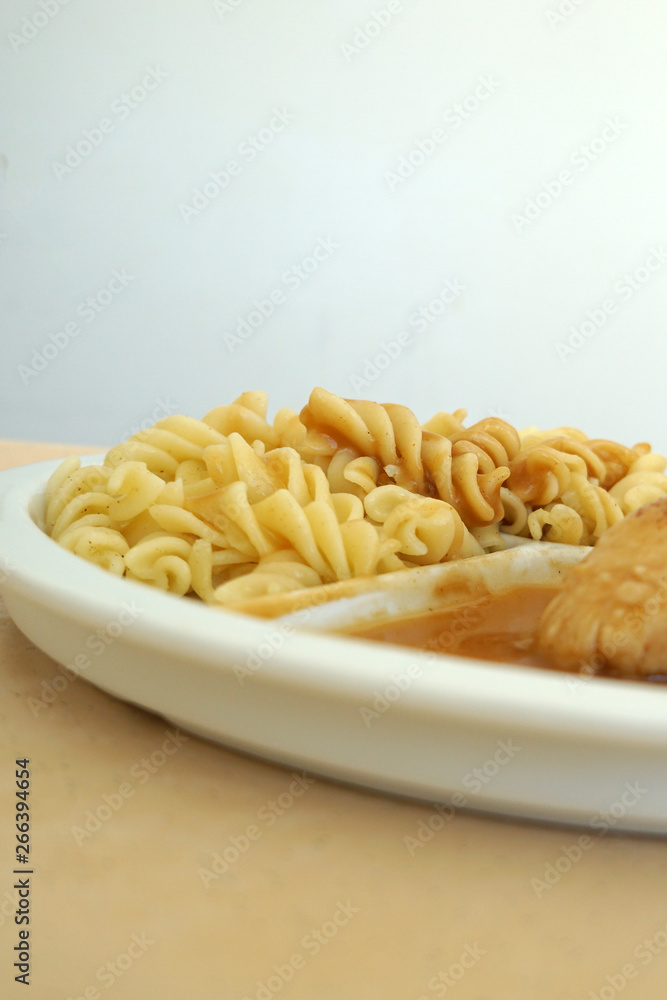 Chicken breast served with noodles and gravy on a tray Chicken breast served with noodles and gravy on a tray