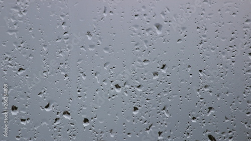 Rain drops on wet glass, gray autumn texture for background