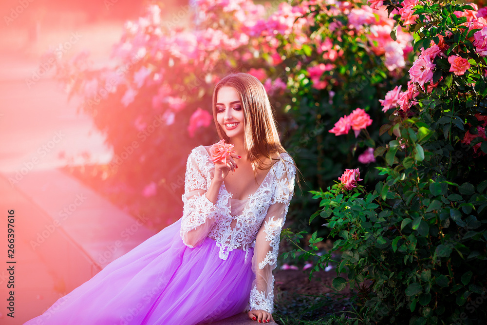 Beautiful girl wearing elegant dress posing near colorful flowers. Art work of romantic woman . Beautiful girl wearing elegant dress posing near colorful flowers. Art work of romantic woman .
