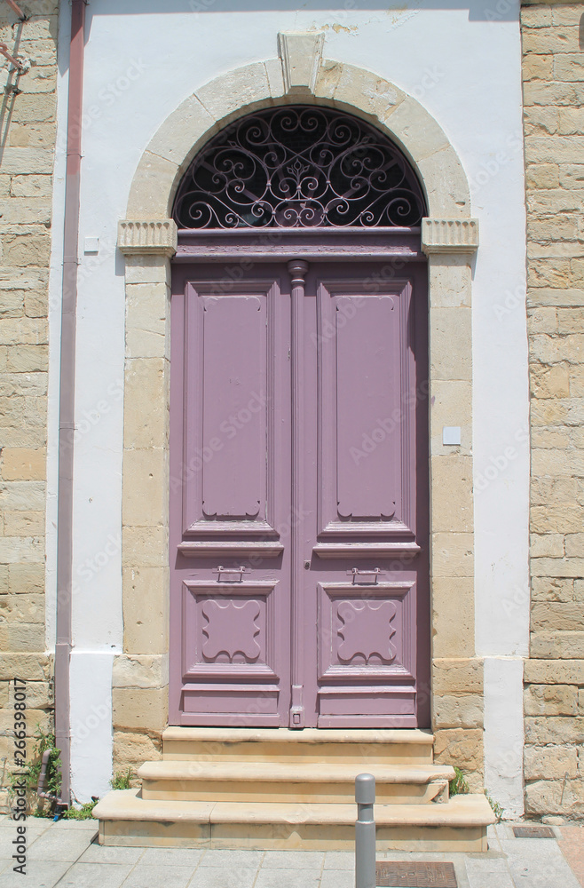 Fototapeta premium Wooden door with stone arch and metal grates