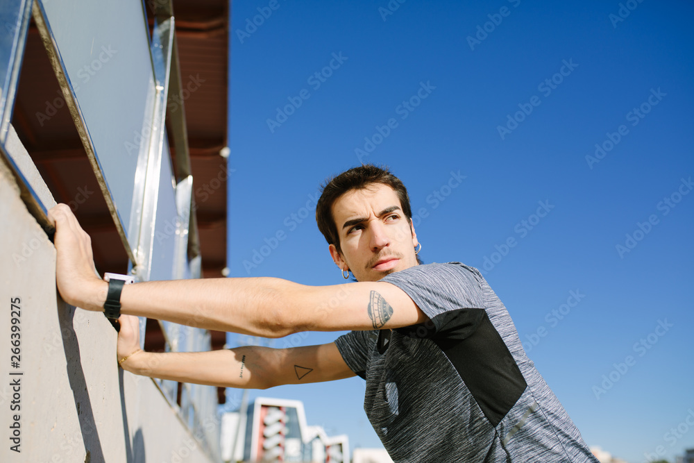 Young man stretching on racetrack Young man stretching on racetrack