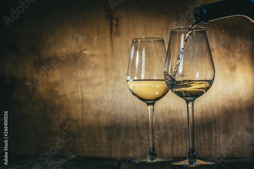 White wine in glasses on rustic background, copy space