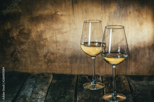 White wine in glasses on rustic background, copy space
