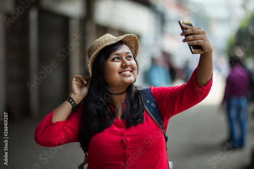 Young beautiful girl taking selfie and laughing in the street of urban area
