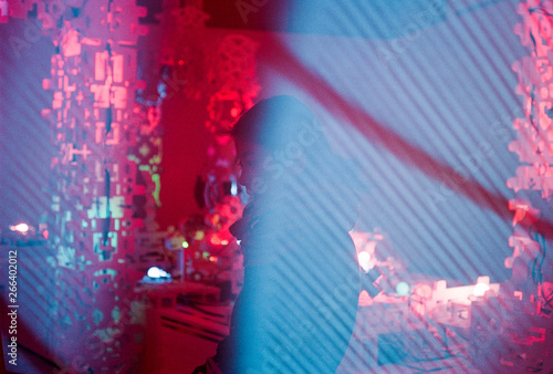 Portrait of woman standing in front of strange red lights covered in blue TV Static