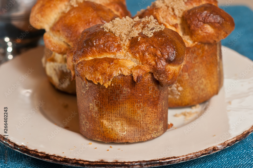 front view, close up of three freshly baked, homemade, honey, pecon monkey bread muffins in paper forms, cooling, on a round, white plate with a gold rim 