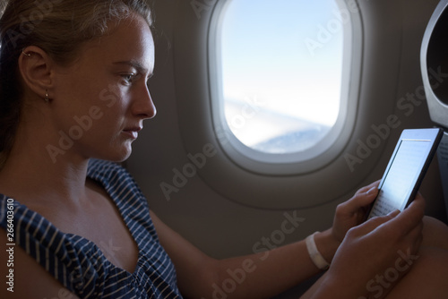 Caucaisan woman with e-reader traveling by plane photo