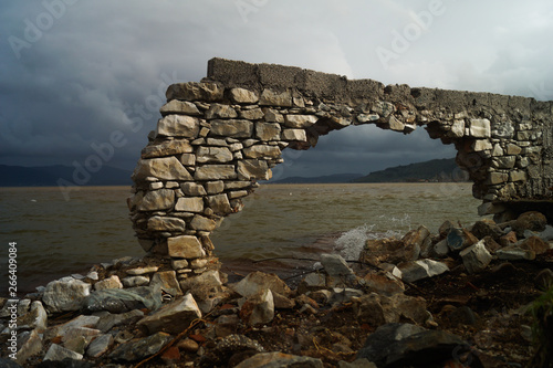 old stone wall at the sea in pigadakia, greece photo