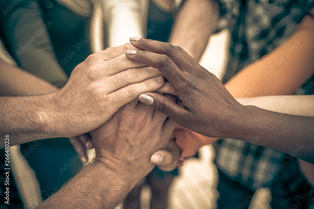 Young people putting their hands together. Friends with stack of hands showing unity and teamwork – Image - obrazy, fototapety, plakaty 