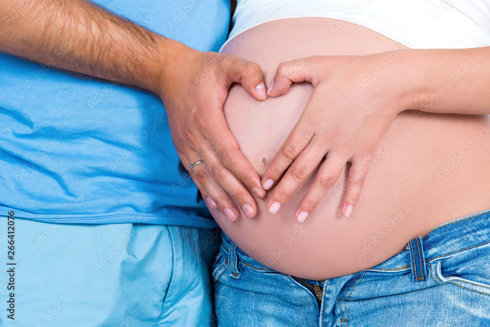 Parental love and happy motherhood. Closeup of heart shape on the background of a pregnant tummy. Parental love and happy motherhood. Closeup of heart shape on the background of a pregnant tummy.