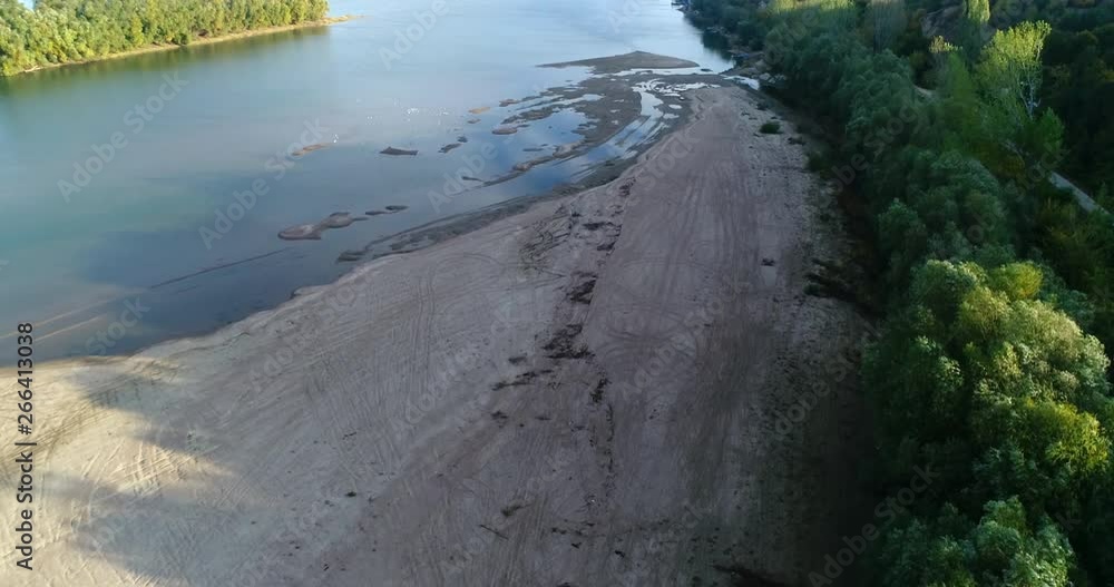 Descending to a river bank with lots of tire tracks on the sand Descending to a river bank with lots of tire tracks on the sand