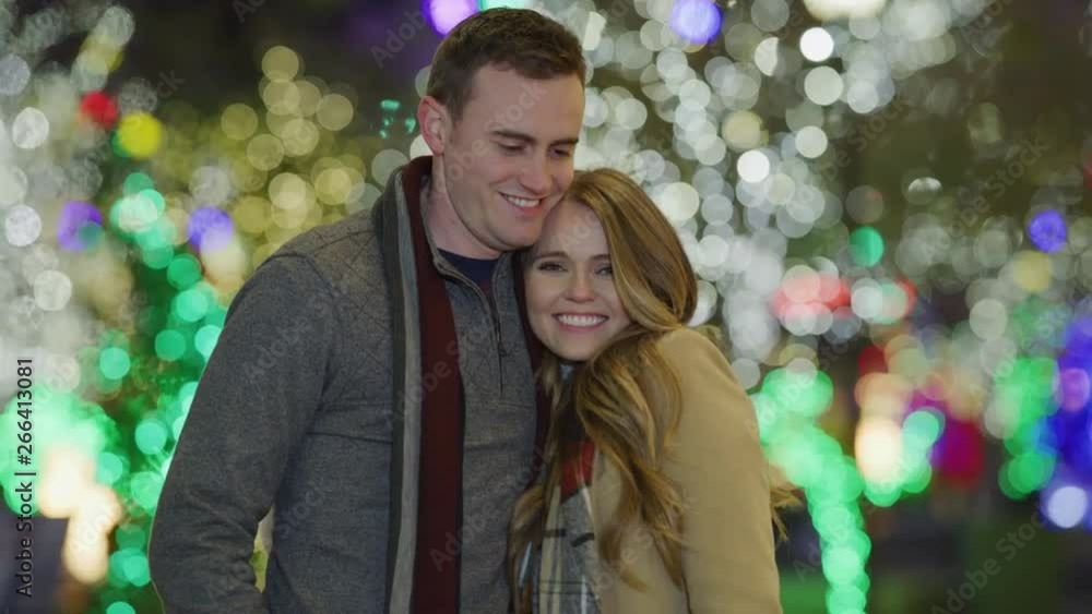 Portrait of happy couple smiling at camera outdoors near Christmas trees / Provo, Utah, United States Portrait of happy couple smiling at camera outdoors near Christmas trees / Provo, Utah, United States